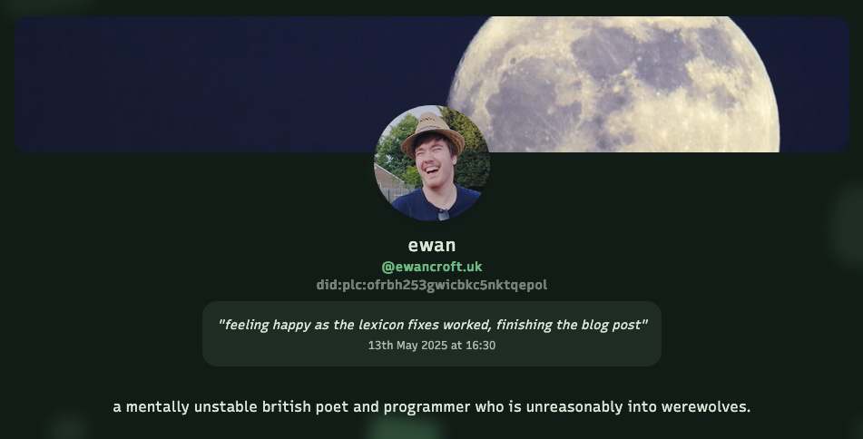 A profile page with a large moon in the background. In the foreground is a circular profile picture of a person wearing a hat and smiling. Below the image is the name 'ewan' with the handle '@ewancroft.uk' and a DID identifier. The profile displays a status message reading 'feeling happy as the lexicon fixes worked, finishing the blog post' dated '13th May 2025 at 16:30'. The profile description states 'a mentally unstable british poet and programmer who is unreasonably into werewolves.'